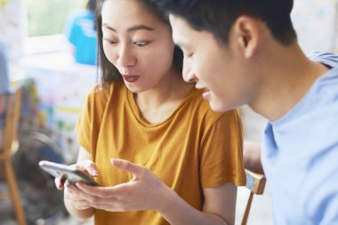 Kafe 'de cep telefonu kullanan Vietnamlı çifti kapatın.