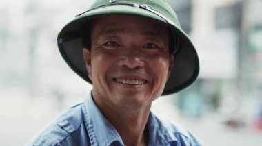 Vietnamlı yetişkin bir adamın kameraya baktığı el kameralı video şovlar. 8 km 'de kırmızı helyum kamerayla çekilmiş.