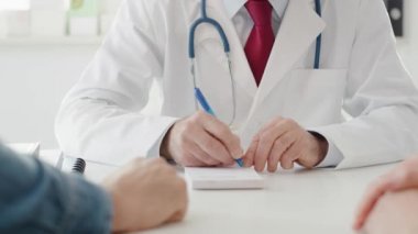 Doktorun, hastası için reçete yazması, elde taşınan bir bakış açısı. 8K 'da kırmızı helyum kamerayla çekildi. 
