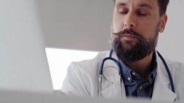 Erkek doktorun laptopta tıbbi sonuçları kontrol ettiği el kamerası görüntüsü. 8 km 'de kırmızı helyum kamerayla çekilmiş.