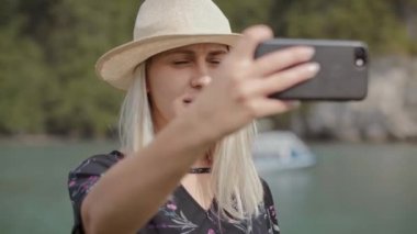 Cep telefonuyla selfie çeken bir kadının el kamerasıyla çekilmiş görüntüleri. 8K 'da kırmızı helyum kamerayla çekildi.