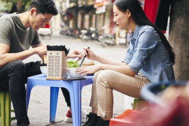 Vietnam 'da sokak yemeği yiyen turistler