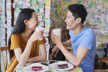 Neşeli çift bir kafede ilginç tartışmalar yapıyor.