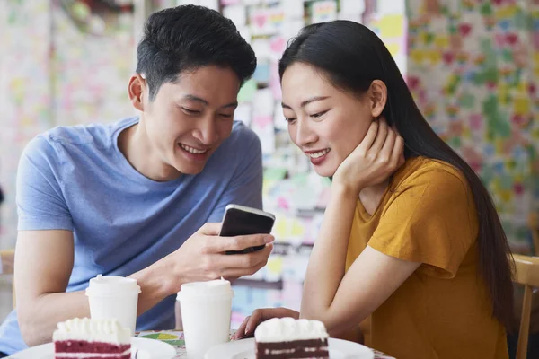 Genç Çift Kafede Cep Telefonundan Bir Şey Kontrol Ediyor — Stok fotoğraf