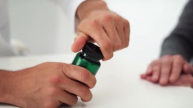 Doktorun kıdemli bir adama hapları vermesi. 8 km 'de kırmızı helyum kamerayla çekilmiş.