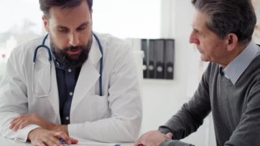 Doktor ve hastanın bazı tıbbi kayıtları tartışırken elde tutulan görüntüsü. 8 km 'de kırmızı helyum kamerayla çekilmiş.