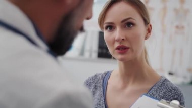 Doktorun genç bir bayanı muayene edişinin el kamerası görüntüsü. 8K 'da kırmızı helyum kamerayla çekildi. 