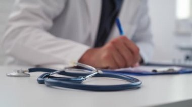 Doktorun tıbbi sonuçları yazması elle görülür bir bakış açısı. 8K 'da kırmızı helyum kamerayla çekildi.