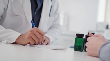 Doktorun, hastası için reçete yazması, elde taşınan bir bakış açısı. 8K 'da kırmızı helyum kamerayla çekildi.