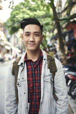 Şehirde sırt çantalı genç Vietnamlı adamın portresi. 