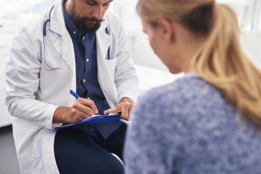 Kadın doktorla hastalığını konuşuyor.