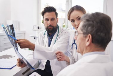 Bir grup doktor radyoloji sonuçlarına bakıyor. 