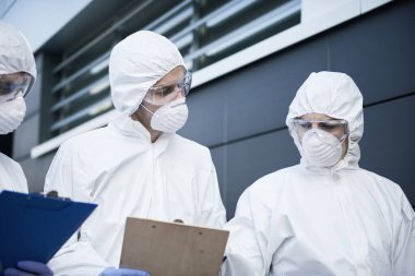 Belgeler üzerinde tartışan bir grup teknisyen