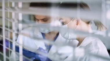 Pencere arkasında iki doktor var. 8K 'da kırmızı helyum kamerayla çekildi..