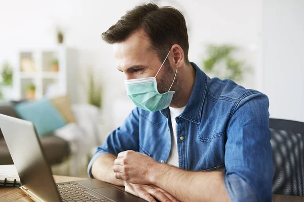  Evde çalışan ve maske takan serbest çalışan biri.