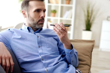 Ev karantinası sırasında cep telefonu kullanan adam