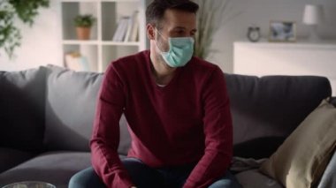 Koruyucu maskeli bir adamın televizyon izlediği video. 8K 'da kırmızı helyum kamerayla çekildi..