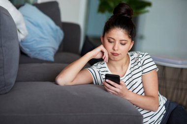 Genç Asyalı kadın evde dijital telefon kullanıyor..