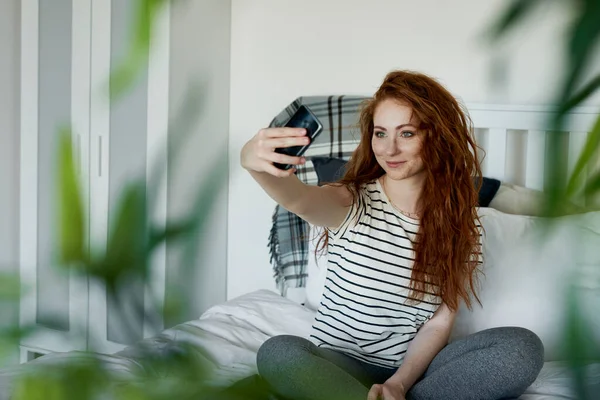Mulher Atraente Tomando Selfie Enquanto Sentado Cama — Fotografia de Stock