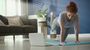 Kadının egzersiz paspası üzerinde egzersiz yaptığı statik video.