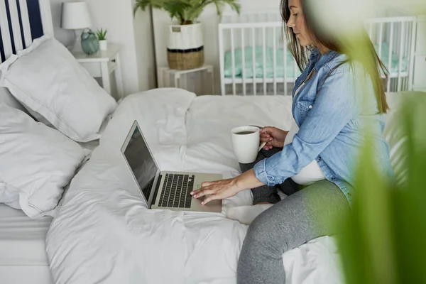 Schwangere Sitzt Auf Bett Und Benutzt Computer — Stockfoto