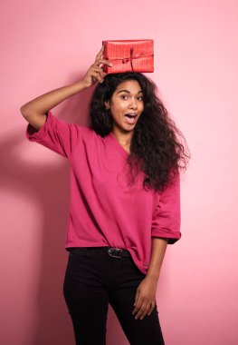 Kafasında hediyeler olan komik yüzlü Afrikalı bir kadın..