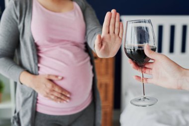 Hamile kadın şarap içmeyi reddediyor.