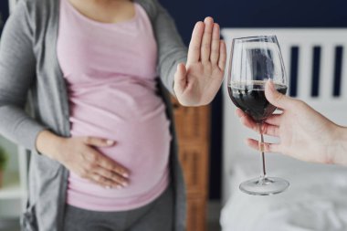 Pregnant woman refusing a glass of wine clipart