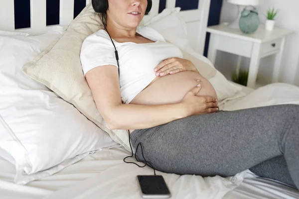 Gravid Kvinna Lyssnar Musik Från Mobiltelefon — Stockfoto