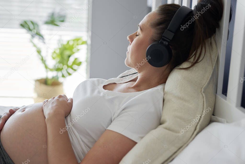 Pregnant woman relaxing while listening to music
