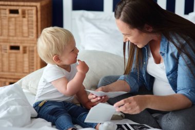 Meraklı çocuk, gelecekteki kardeşinin resimlerini izliyor.