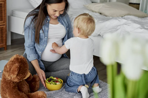 Little Brother Feeding Fruits His Future Sibling — Stock Photo, Image