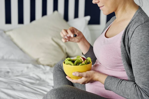 妊娠中の女性は健康的なフルーティーなスナックを食べる — ストック写真