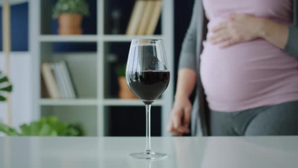 妊娠中の女性が赤ワインを飲みながらビデオ 8Kでレッドヘリウムカメラで撮影 — ストック動画