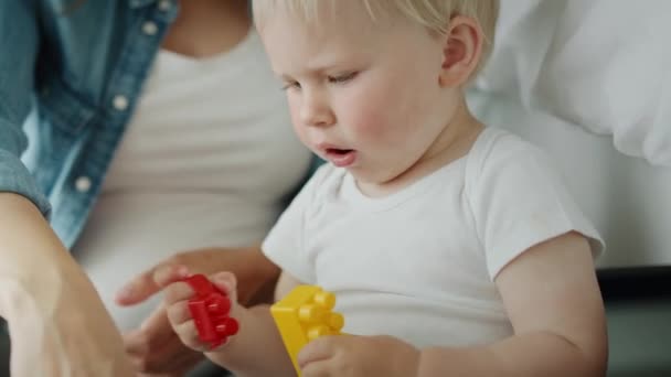おもちゃのブロックで遊んでいる母親と彼女の幼児のビデオ 8Kでレッドヘリウムカメラで撮影 — ストック動画