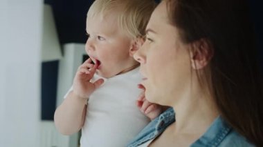 Anne ve bebeğinin pencereden baktığı videoyu kapat. 8K 'da kırmızı helyum kamerayla çekildi.  
