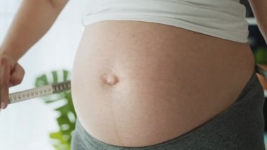 Karnını ölçen hamile kadının videosunu kapat. 8K 'da kırmızı helyum kamerayla çekildi.  
