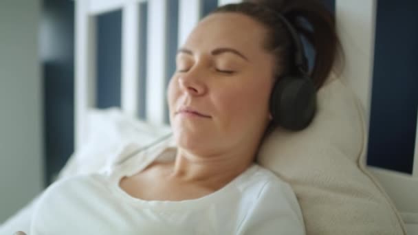 妊娠中の女性が音楽を聴いているビデオを閉じます 8Kでレッドヘリウムカメラで撮影 — ストック動画