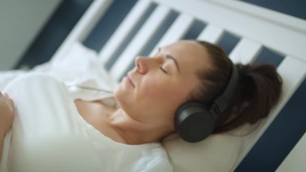 妊娠中の女性の音楽を聞いてビデオをズームアウト 8Kでレッドヘリウムカメラで撮影 — ストック動画
