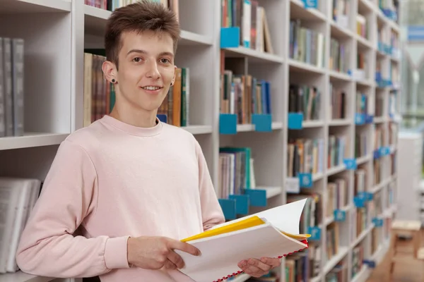 Unge man i biblioteket eller bokhandeln — Stockfoto