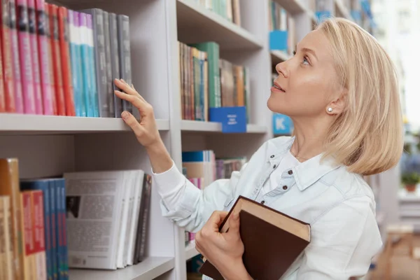 Jovem encantadora na biblioteca ou livraria — Fotografia de Stock