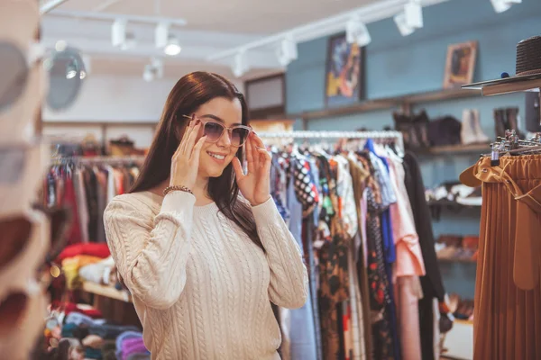 Mulher feliz bonita gostando de fazer compras na loja de roupas — Fotografia de Stock