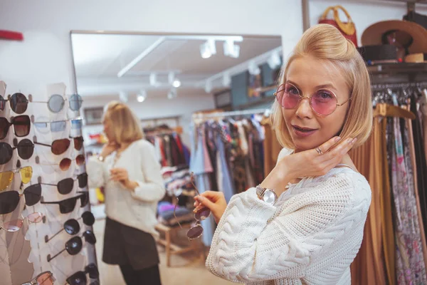 Mulher feliz bonita gostando de fazer compras na loja de roupas — Fotografia de Stock