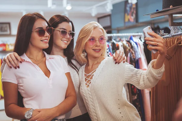 Amigos do sexo feminino fazendo compras juntos na loja de roupas — Fotografia de Stock