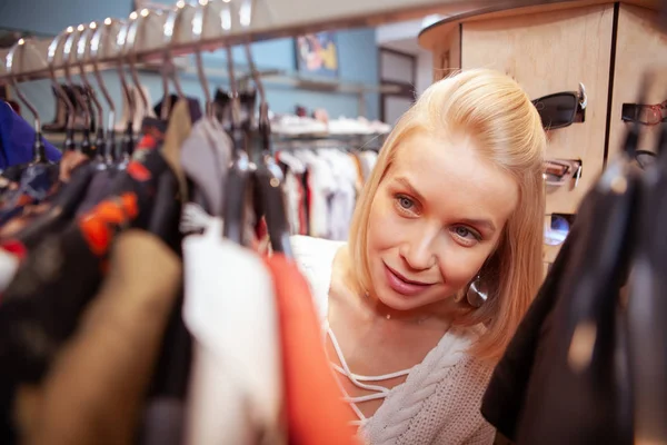 Mulher feliz bonita gostando de fazer compras na loja de roupas — Fotografia de Stock