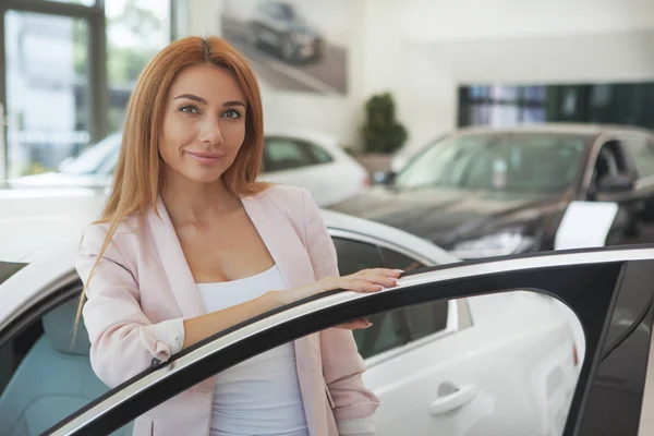 Gorgeous woman choosing a new car at the dealership — Stock Photo, Image