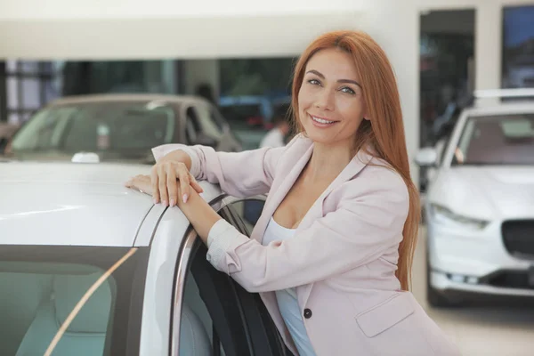 Splendida donna che sceglie una nuova auto presso la concessionaria — Foto Stock