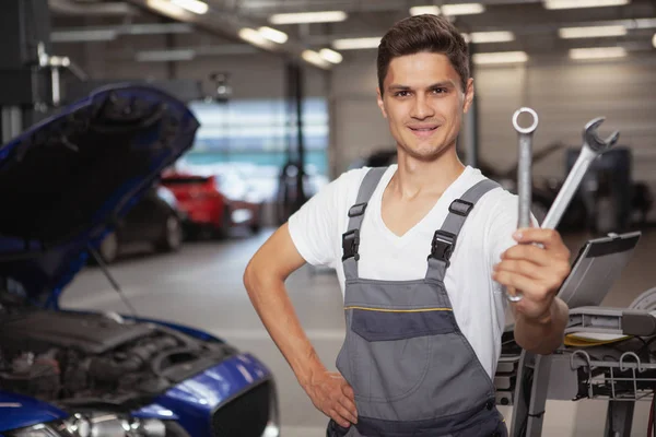 Joven mecánico de coches guapo reparación de vehículos en su garaje —  Fotos de Stock