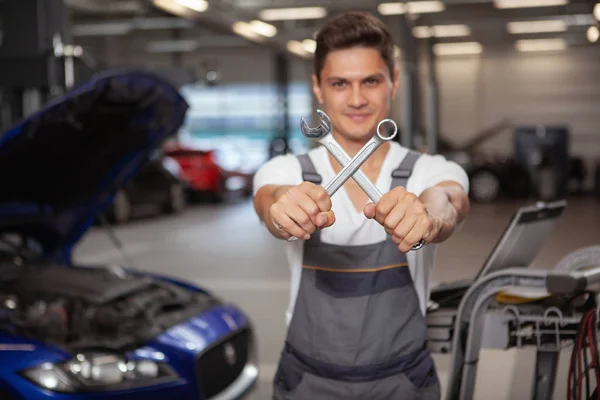 Jovem carro bonito mecânico reparando veículo em sua garagem — Fotografia de Stock