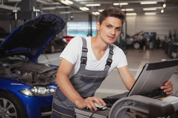 Joven mecánico de coches guapo reparación de vehículos en su garaje —  Fotos de Stock
